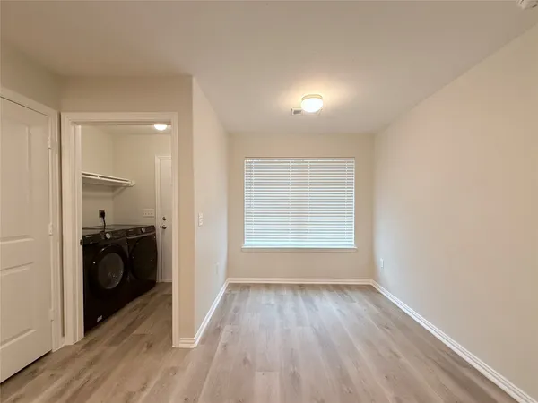 wooden floor in an empty room with a kitchen