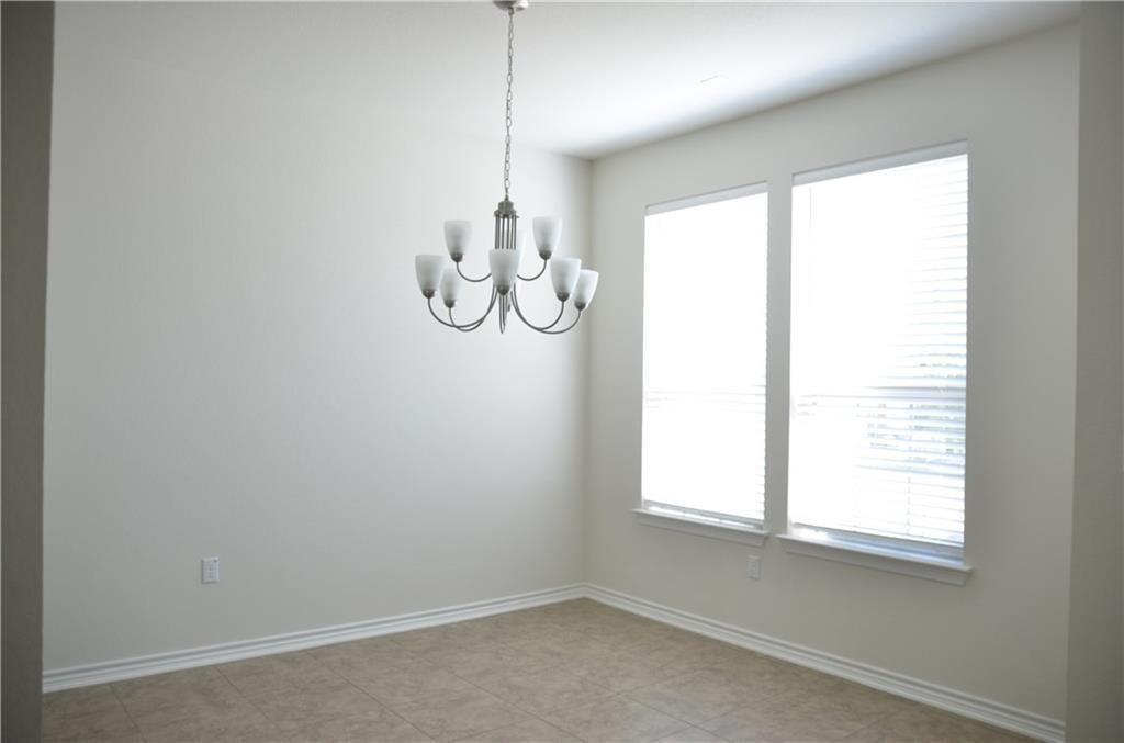 14403 McCoy Loop Austin, TX 78717 - Photo 4 of 29 A classic chandelier illuminates this spacious dining area with ample natural light from tall windows.