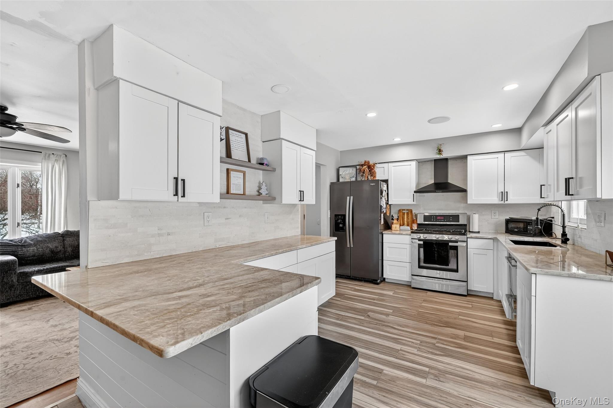 917 Scotchtown Collabar Road Middletown, NY 10941 - Photo 11 of 33 a kitchen with stainless steel appliances granite countertop a stove top oven a refrigerator and white cabinets with wooden floor