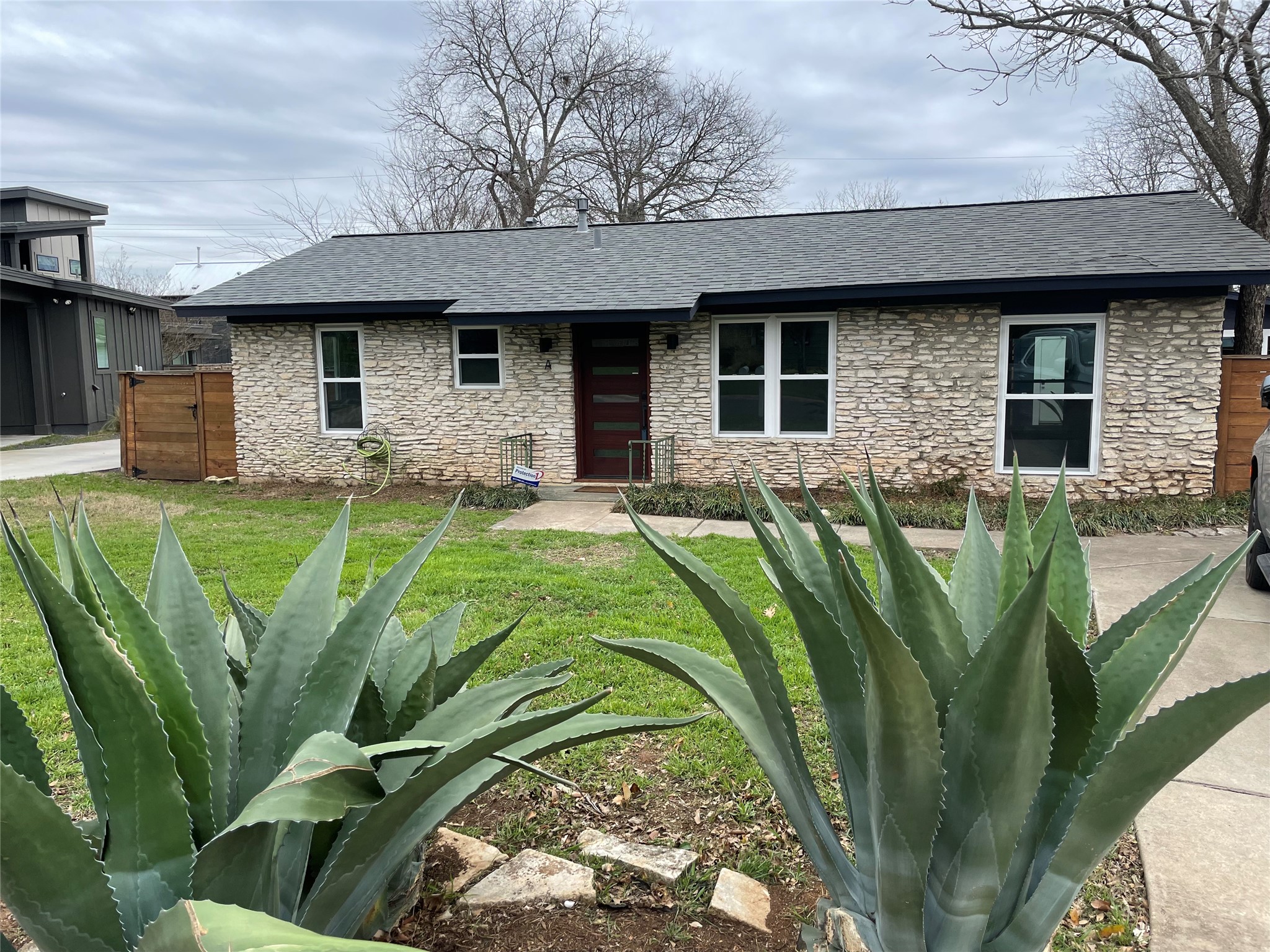 4619 Jinx Avenue, Unit A Austin, TX 78745 - Photo 15 of 21 Stone-clad exterior featuring a charcoal shingle roof and dark trim
