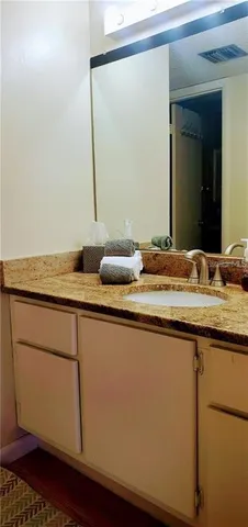 a bathroom with a granite countertop sink and a mirror