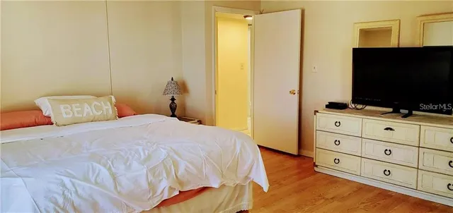 a bedroom with a bed and a flat tv screen on dresser