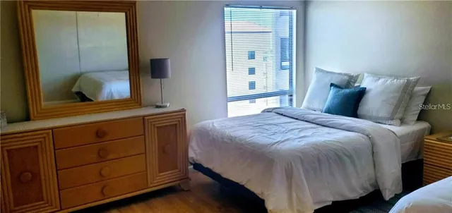 a bedroom with a bed and a mirror on dresser