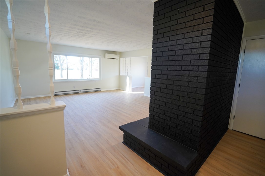 8746 Grubbs-Rex Road Arcanum, OH 45304 - Photo 24 of 38 This living room features a striking fireplace and expansive windows, offering a bright and inviting atmosphere.