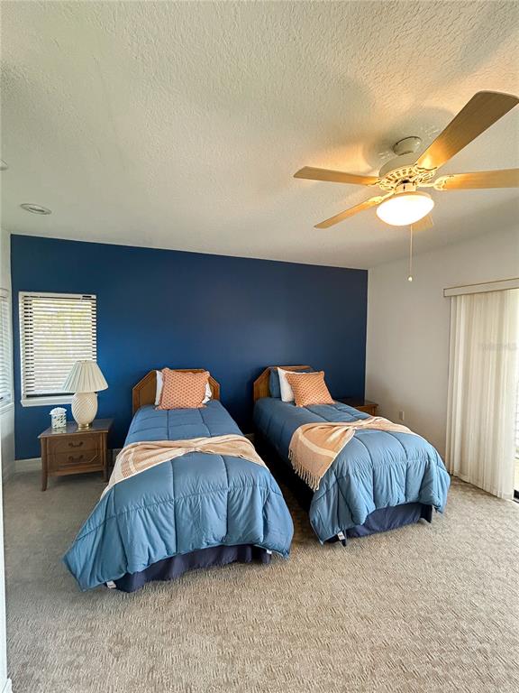 7303 Midnight Pass Road Sarasota, FL 34242 - Photo 17 of 22 a bedroom with two beds and a chandelier