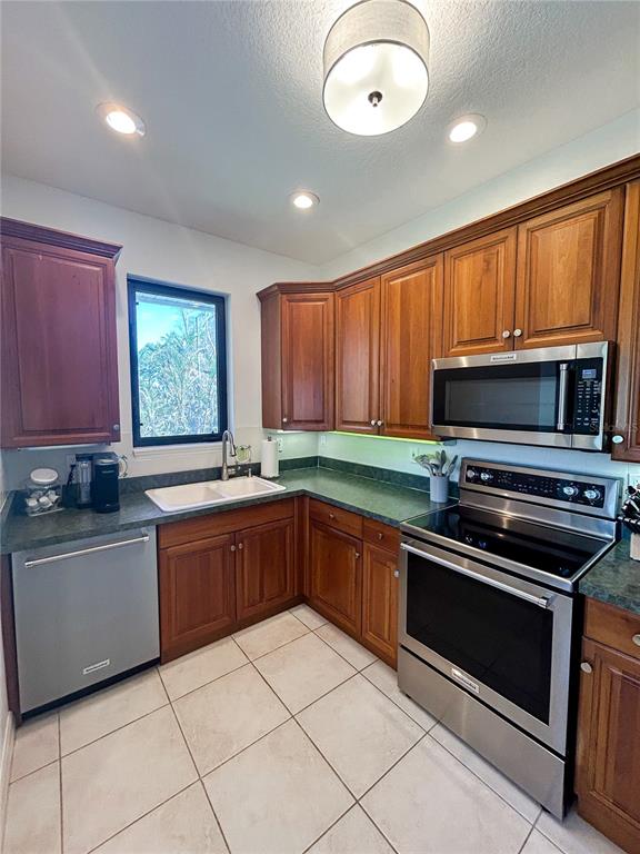 7303 Midnight Pass Road Sarasota, FL 34242 - Photo 5 of 22 a kitchen with stainless steel appliances granite countertop a stove top oven microwave and cabinets