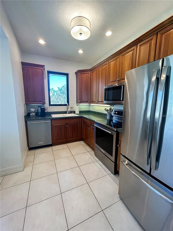 7303 Midnight Pass Road Sarasota, FL 34242 - Photo 7 of 22 a kitchen with stainless steel appliances granite countertop a refrigerator and a stove top oven