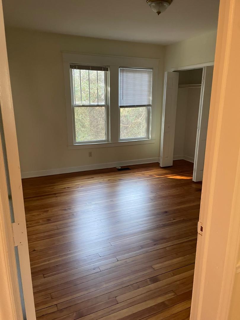 716 Crosby Road Durham, NC 27704 - Photo 12 of 17 an empty room with wooden floor and windows
