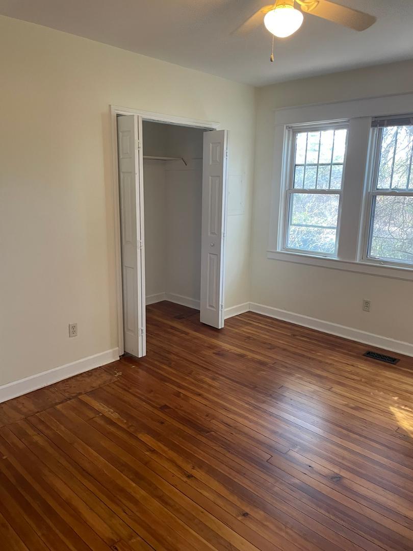 716 Crosby Road Durham, NC 27704 - Photo 13 of 17 an empty room with wooden floor and windows