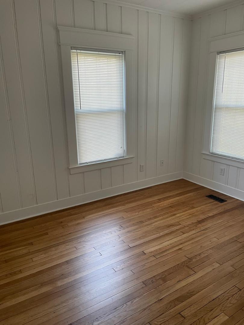 716 Crosby Road Durham, NC 27704 - Photo 14 of 17 an empty room with wooden floor and windows