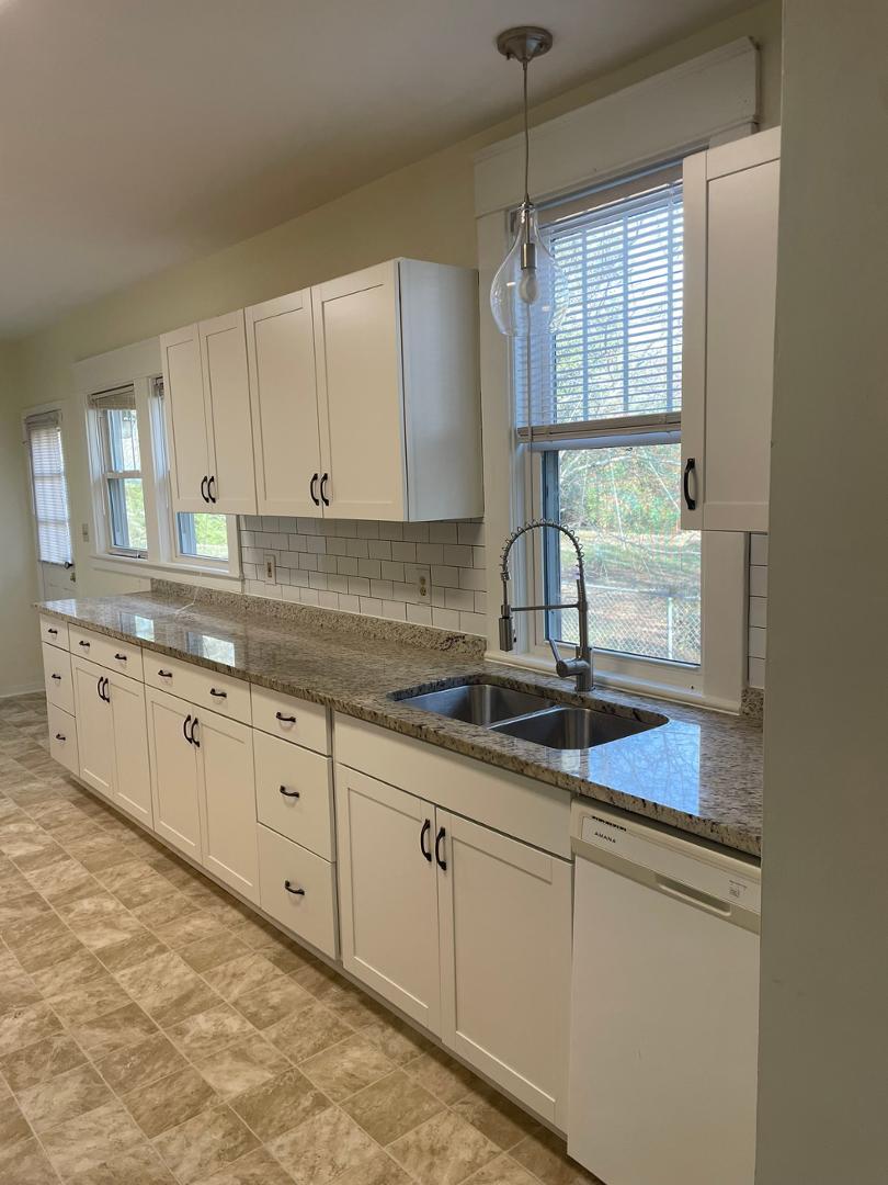716 Crosby Road Durham, NC 27704 - Photo 2 of 17 a kitchen with granite countertop white cabinets and white appliances