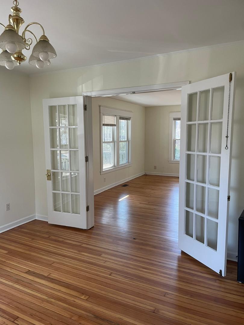 716 Crosby Road Durham, NC 27704 - Photo 7 of 17 an empty room with wooden floor and windows
