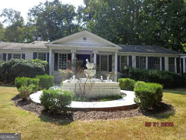 a front view of a house with a yard and potted plants
