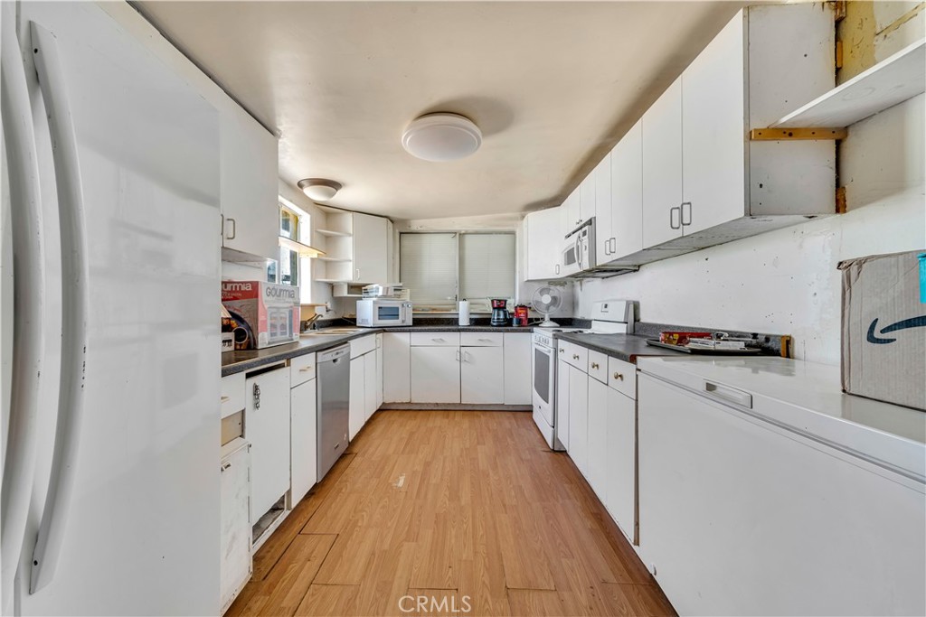 26447 Twenty Mule Team Road Boron, CA 93516 - Photo 37 of 61 a kitchen with cabinets a sink and white appliances