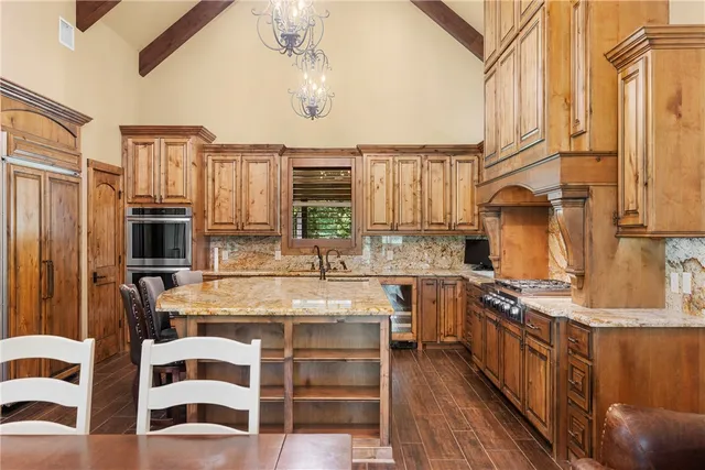 a kitchen with stainless steel appliances kitchen island granite countertop a stove and cabinets