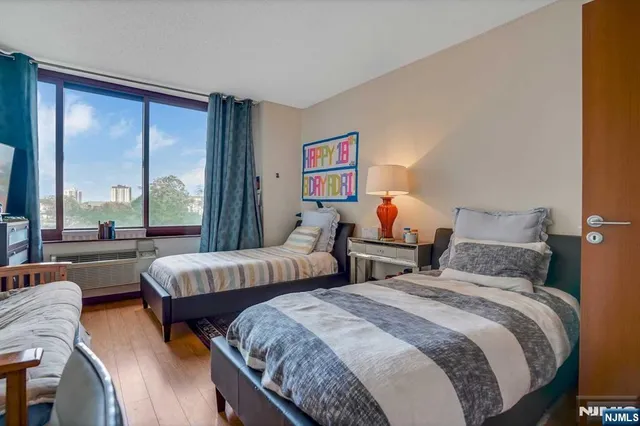 a bedroom with two beds and a large window with outer view