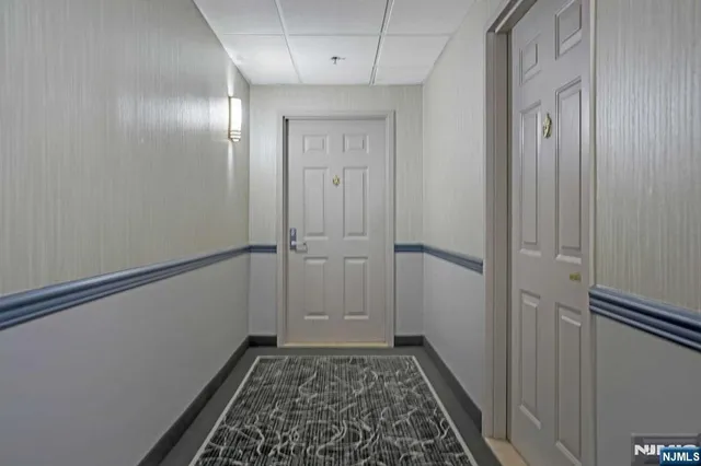 a view of hallway with closet and wooden floor