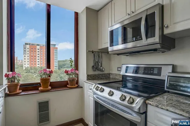 a kitchen with stainless steel appliances granite countertop a stove and a microwave