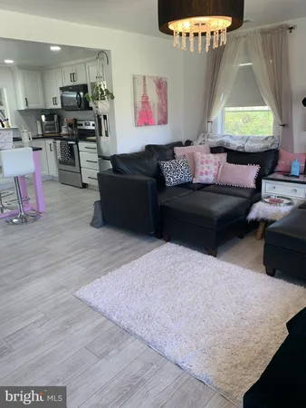 a kitchen with granite countertop a refrigerator a sink a stove a microwave and wooden floor