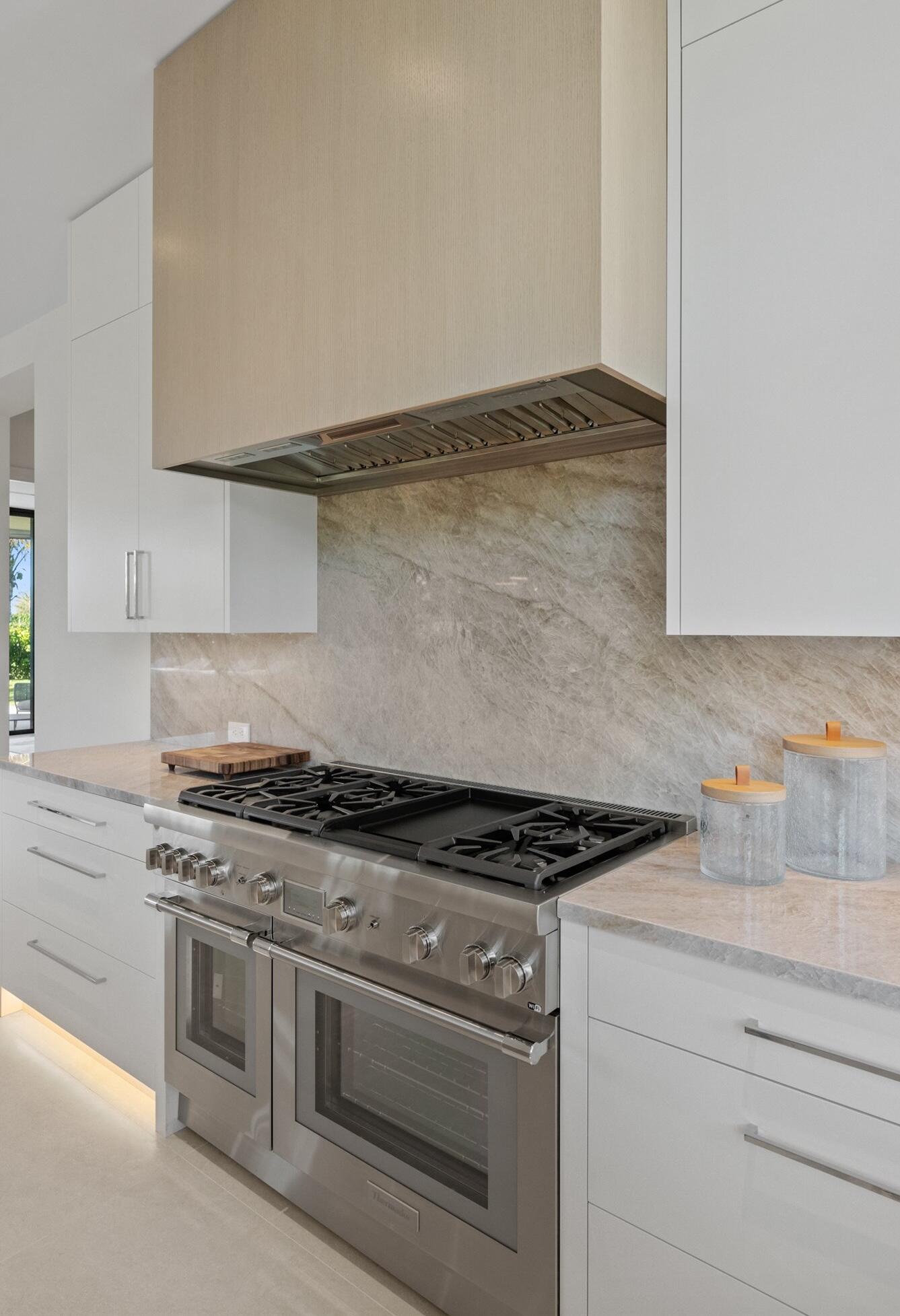 11368 Polo Park Trail Wellington, FL 33414 - Photo 27 of 33 a kitchen with granite countertop a stove and a white cabinets