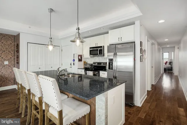 a kitchen with kitchen island a counter top space appliances and cabinets