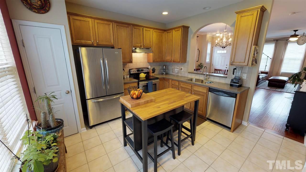 5233 Moonview Court Raleigh, NC 27606 - Photo 3 of 25 42 Inch Glazed Raised Panel Cabinets, Solid Surface Countertops, Stainless Steel Appliances, Tile Flooring