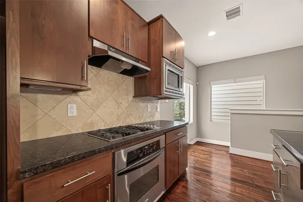 a kitchen with granite countertop a stove and a refrigerator