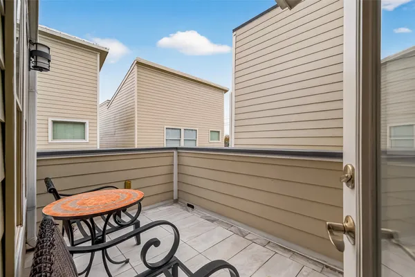 a balcony with table and chairs