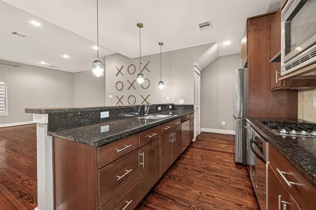 a kitchen with a stove and a wooden floor