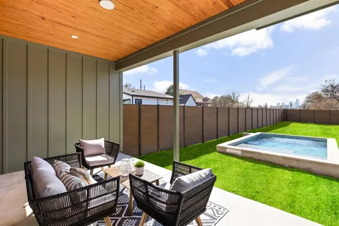 a view of a house with backyard and sitting area