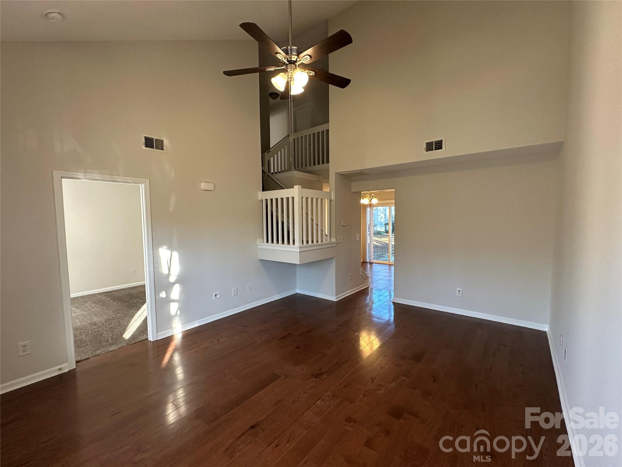 5227 Magnolia Tree Lane Charlotte, NC 28215 - Photo 5 of 20 a view of an empty room with wooden floor and a ceiling fan