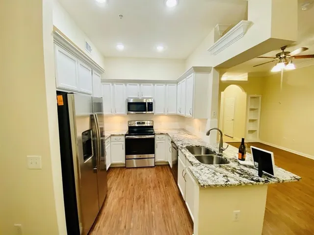a kitchen with a sink a refrigerator a stove top oven and cabinetry