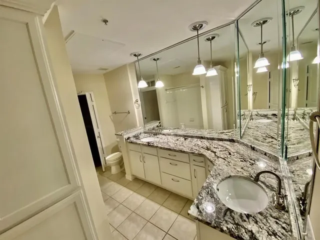 a bathroom with a granite countertop sink a mirror and shower