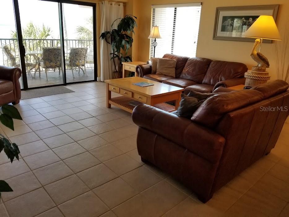 13650 Gulf Boulevard, Unit 304 Madeira Beach, FL 33708 - Photo 23 of 63 a living room with furniture and a floor to ceiling window