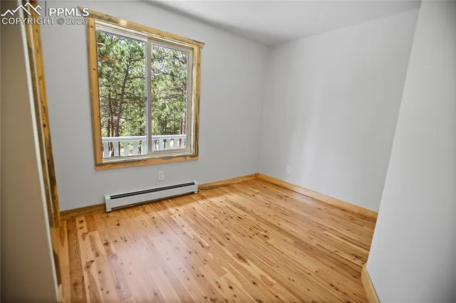 an empty room with a window and wooden floor