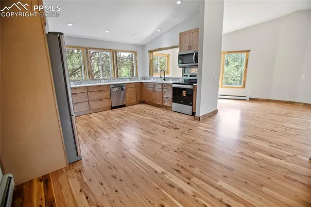 a view of an empty room with a fireplace and a window