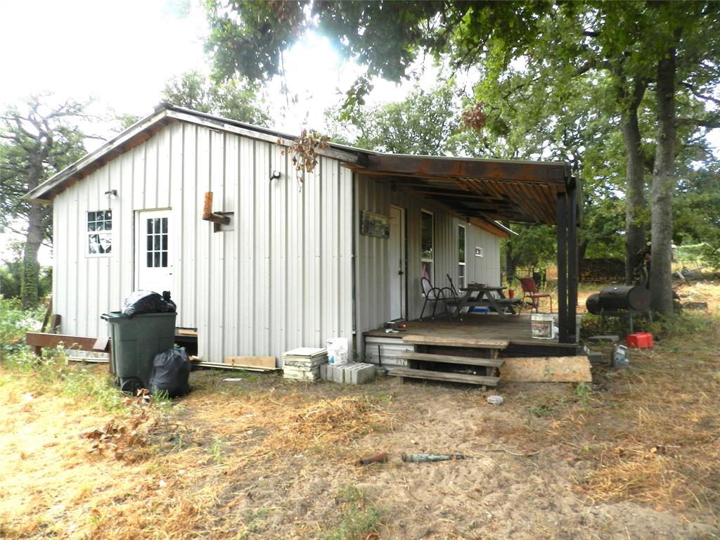 588 Salt Creek Road Springtown, TX 76082 - Photo 7 of 19 Metal siding exterior with a gabled roofline