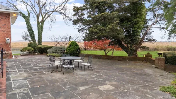 a view of a patio with table and chairs under an umbrella