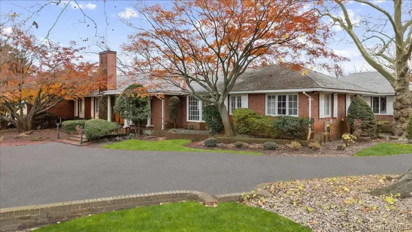 a front view of a house with a yard and potted plants