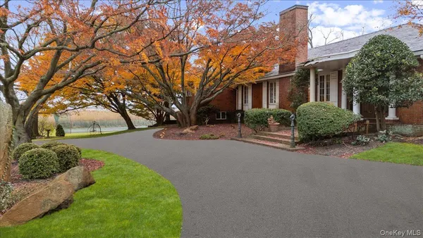 a front view of a house with a garden and trees