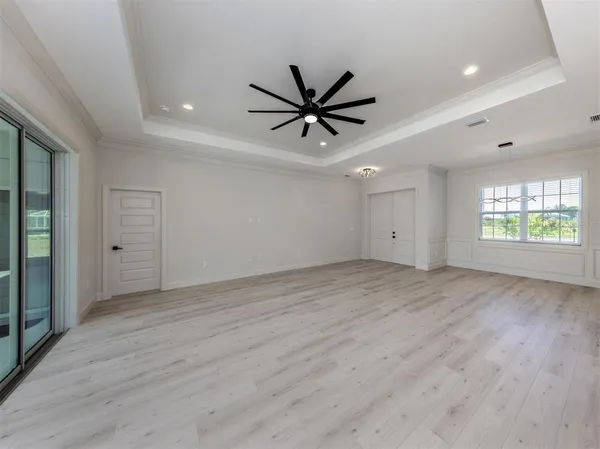an empty room with window and a ceiling fan