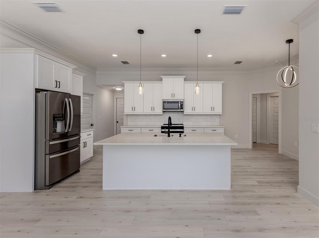 65 Fairway Road Rotonda West, FL 33947 - Photo 15 of 40 a large kitchen with stainless steel appliances a refrigerator a stove a sink and a oven