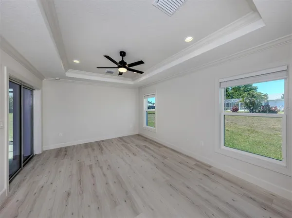 a view of empty room with wooden floor and fan