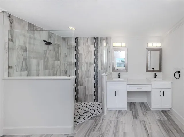 a spacious bathroom with a double vanity sink a large mirror and shower