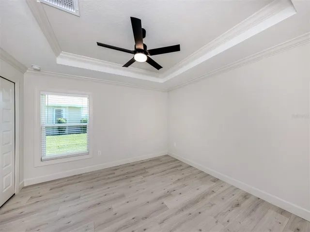 an empty room with a window and a ceiling fan