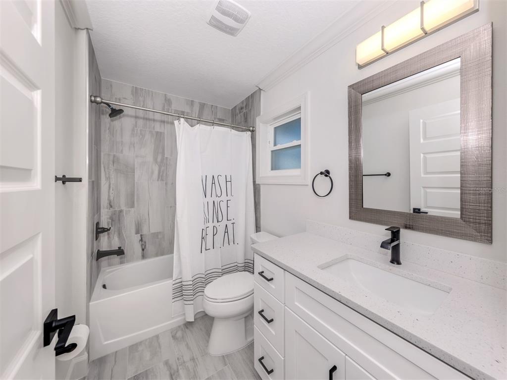 65 Fairway Road Rotonda West, FL 33947 - Photo 29 of 40 a bathroom with a sink a toilet and a large mirror