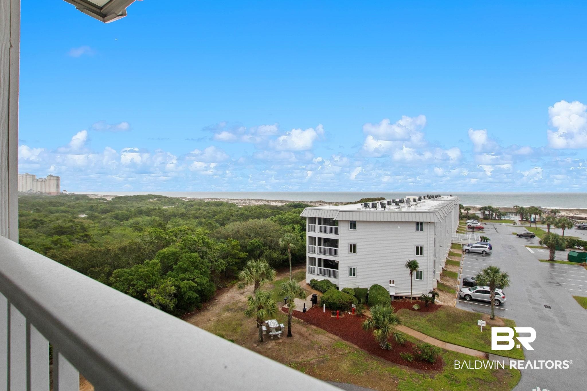 400 Plantation Road, Unit 4501 Gulf Shores, AL 36542 - Photo 8 of 30 Expansive coastal landscape featuring a broad ocean horizon, lush green foliage, and a contemporary multi-story building