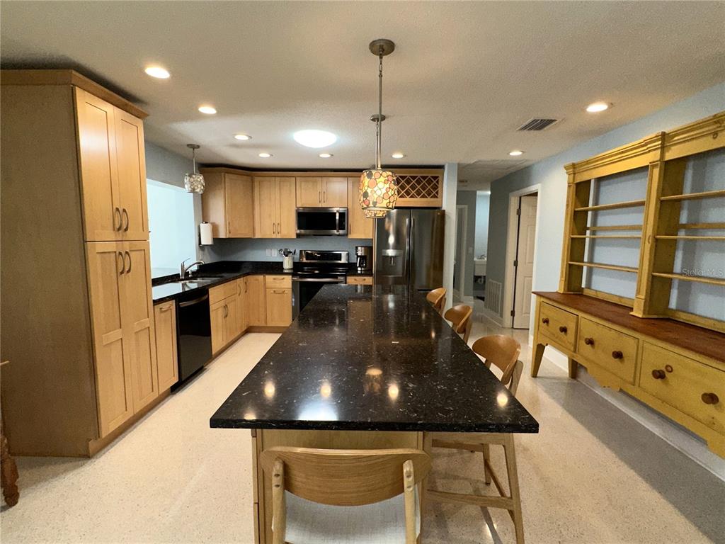 1883 Riviera Circle Sarasota, FL 34232 - Photo 12 of 45 a kitchen with stainless steel appliances granite countertop a sink a stove a refrigerator cabinets and chairs