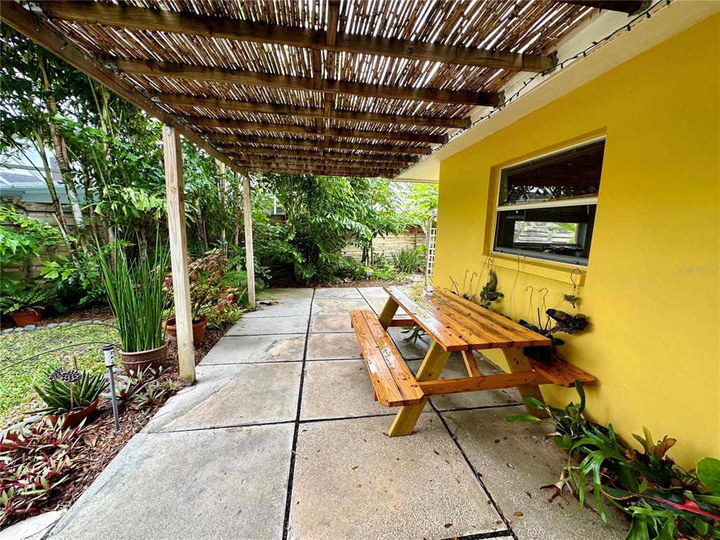 1883 Riviera Circle Sarasota, FL 34232 - Photo 4 of 45 a patio with table and chairs with potted plants and big yard