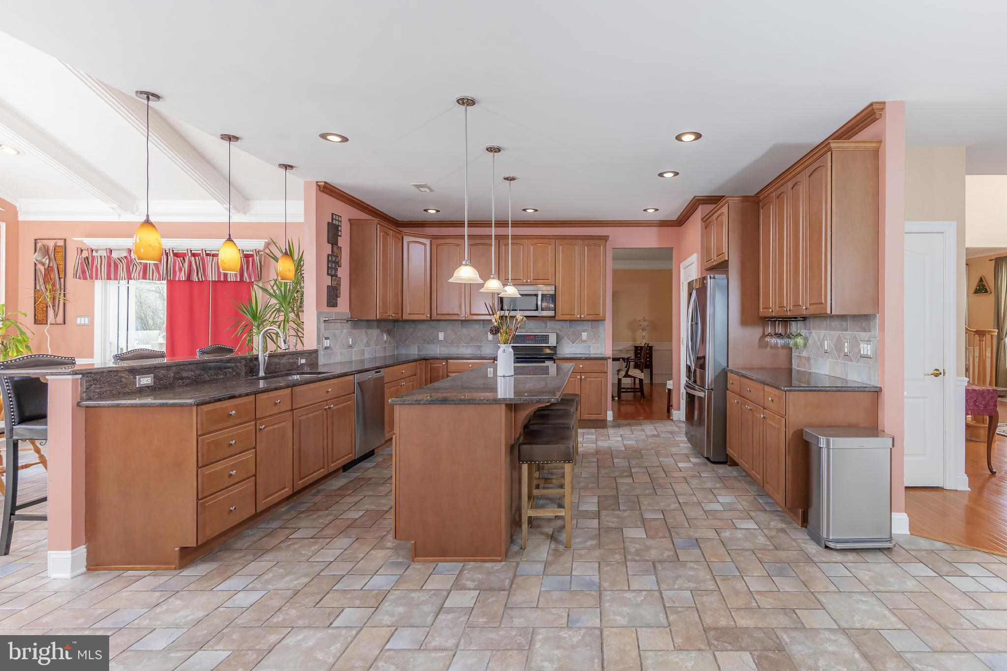 612 Bainbridge Drive Mullica Hill, NJ 08062 - Photo 14 of 42 a kitchen with granite countertop a refrigerator a stove top oven a sink dishwasher and cabinets with wooden floor
